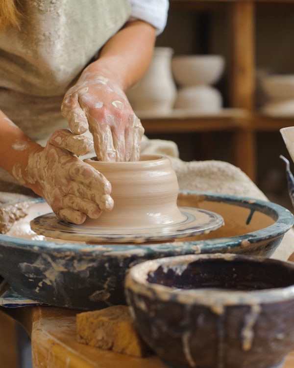 hands of a potter, creating an earthen jar on the circle